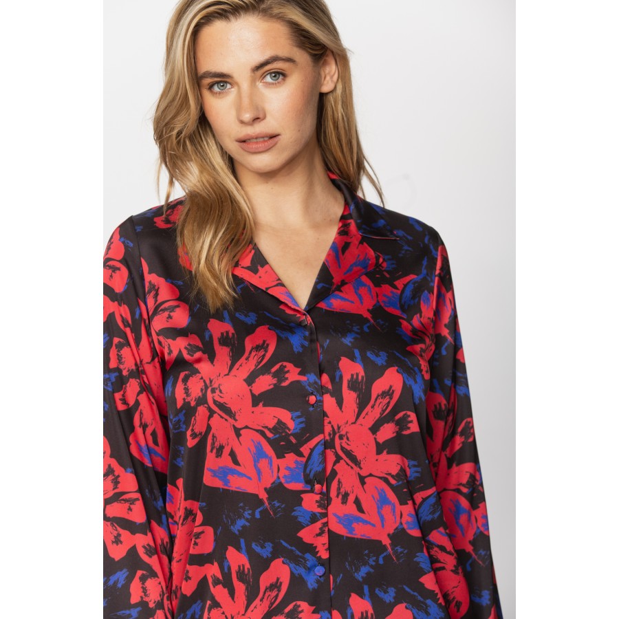 Satin pyjamas in a blue and red print on a black background, nightshirt-style top and bottoms