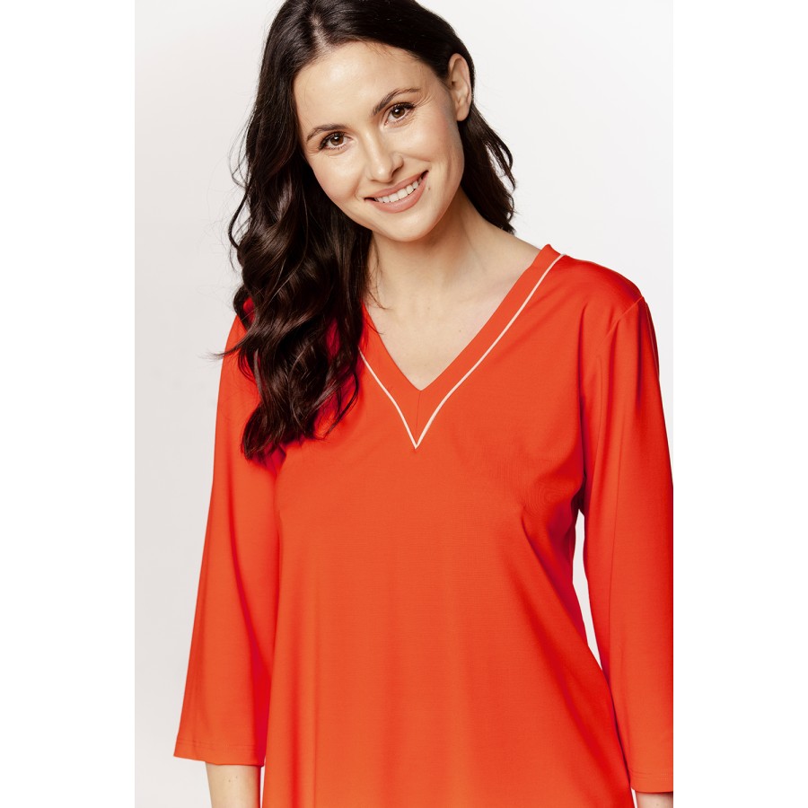 Loose-fitting silk pajama set with V-neck trim, pants, and ¾ sleeves