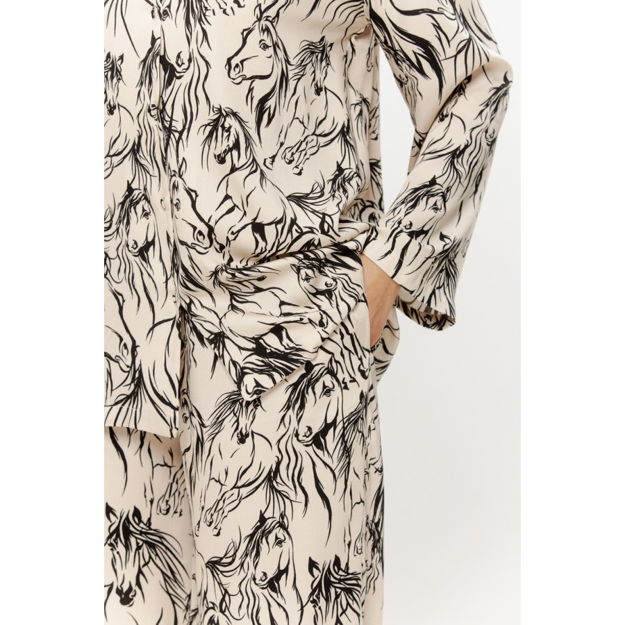 Gros plan tissu viscose soyeux, col chemise boutonné, manche longue